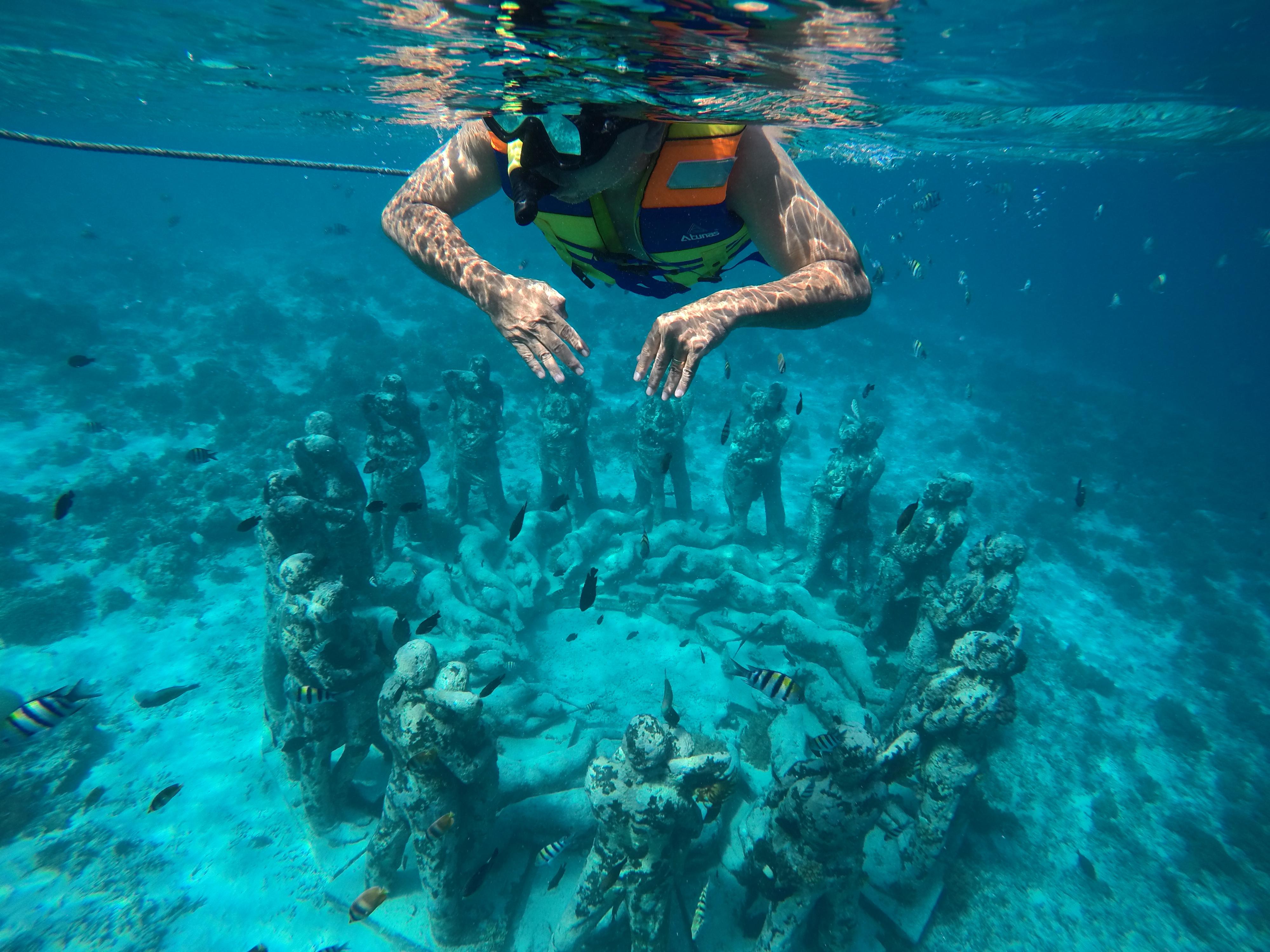 Snorkeler swimming above the underwater statues near Gili Meno